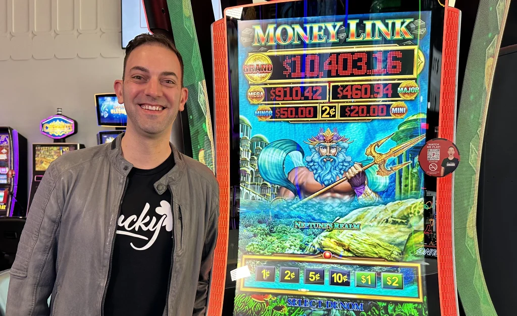 Brian Christopher standing next to the Money Link slot machine