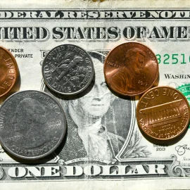 Change on top of a dollar bill