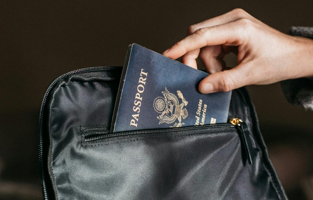 hand taking passport out of bag