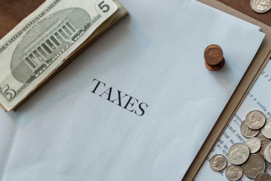 Tax documents with loose cash and coins around