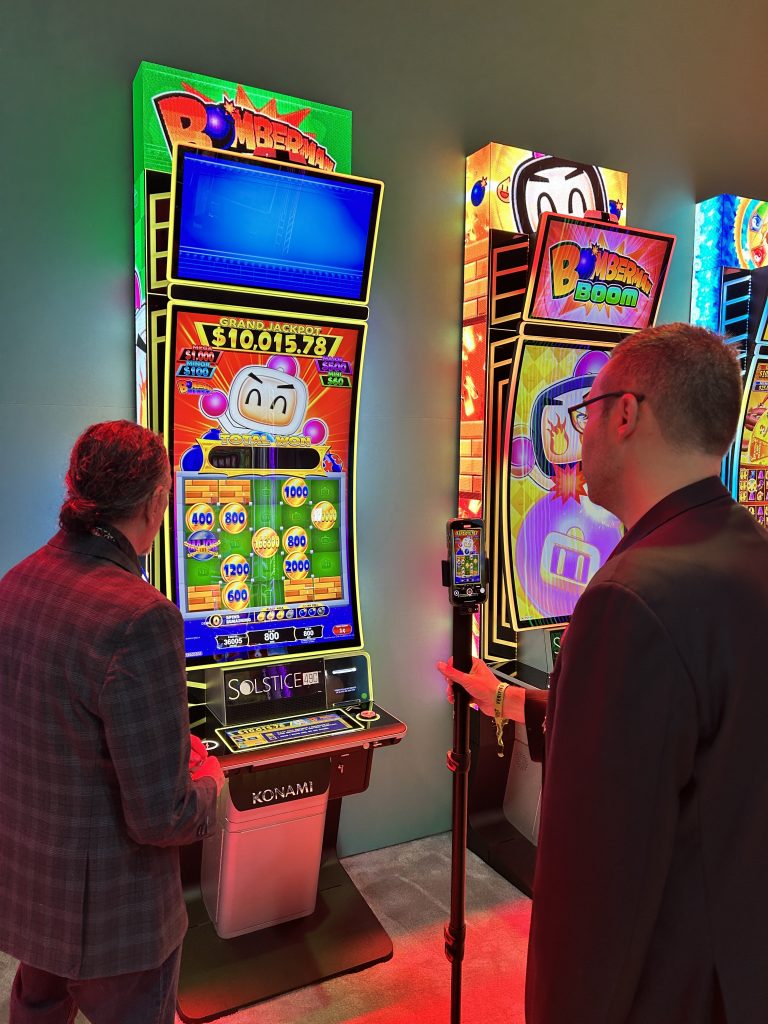 Flip The Switch editor Josh O'Connell gets a preview of a Bomberman themed slot at the Konami booth during Global Gaming Expo 2025.