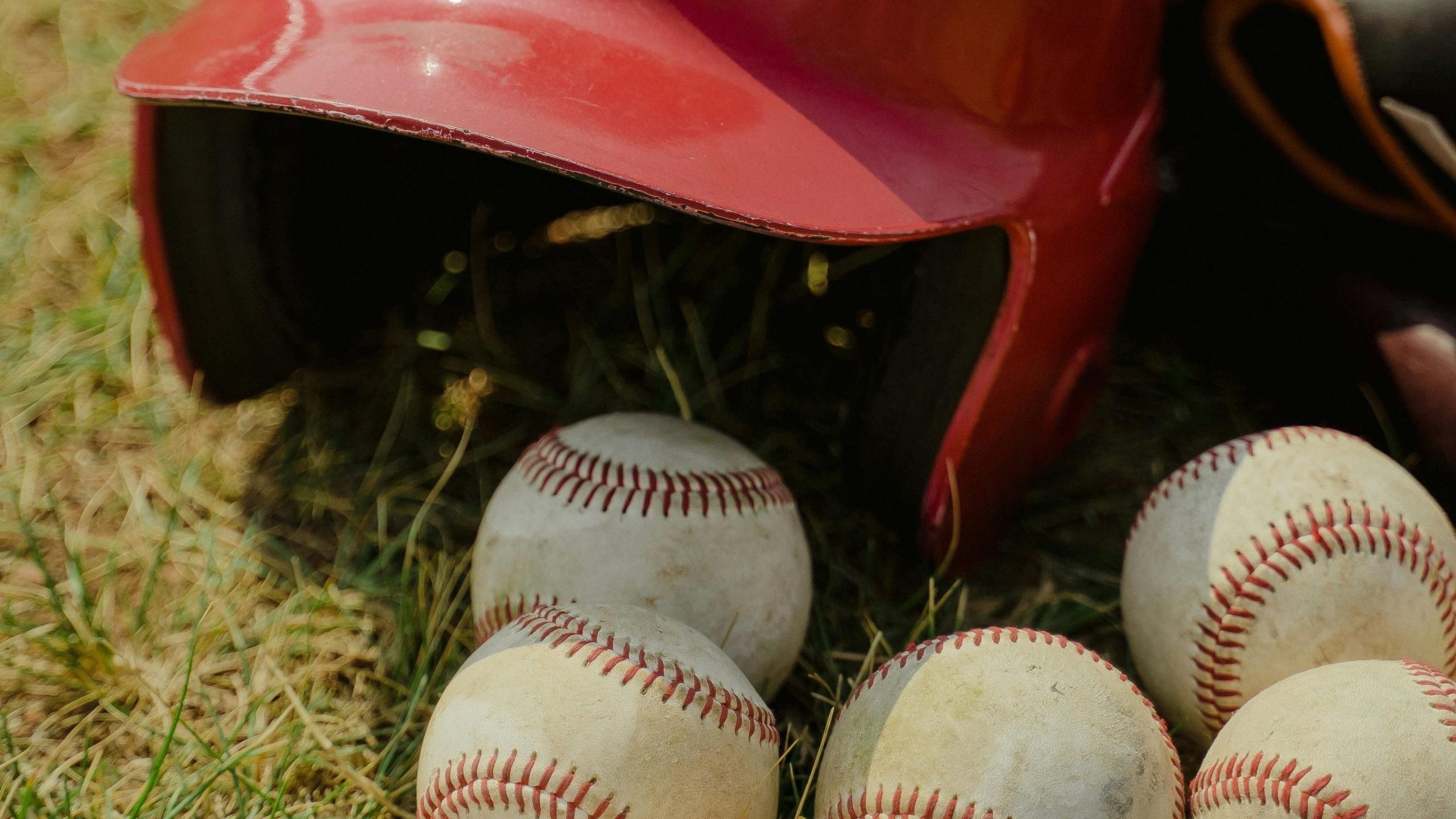 baseball helmet and bat surrounded by baseballs