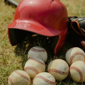 baseball helmet and bat surrounded by baseballs