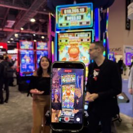 Josh O'Connell and Bree Cardona discuss a new slot at the Eclipse booth during G2E 2026 in Las Vegas, Nevada.